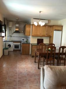 a kitchen and dining room with a table and chairs at Casa Rural las Escuelas II in Hoyo de Pinares