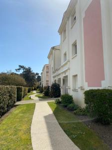 uma passagem em frente a um edifício branco em Le Pontappart em Royan