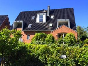 a red brick house with a black roof at 2 Zimmer Appartement Ostseeblick in Boltenhagen