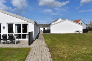 una casa blanca con una mesa y sillas en un patio en Kerteminde Byferie - Hyrdevej 83, 85K en Kerteminde