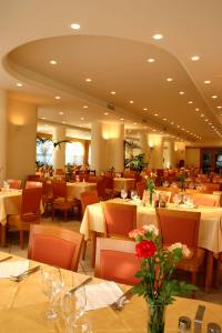 カーポ・ヴァチカーノにあるHotel Grotticelleの花のテーブルと椅子が並ぶレストラン