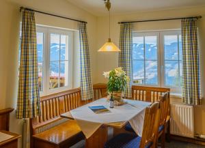 a dining room with a table and two windows at Alpengasthof Enzian GmbH in Mönichkirchen