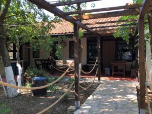 a wooden pergola with a hammock in a yard at Grauri si Smochini in Vadu