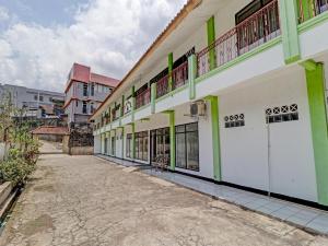 un bâtiment vert et blanc dans l'établissement OYO 90621 Pondok 23, à Cilimus 2