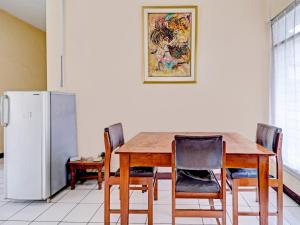 a kitchen with a table and chairs and a refrigerator at OYO 90621 Pondok 23 in Cilimus 2
