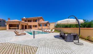 a house with a swimming pool and an umbrella at Pool Terrace Relax & Fun Villa Fuma in Loborika