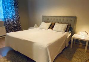 a bedroom with a large white bed and a window at FlatsinRoi Apartments in Rovaniemi