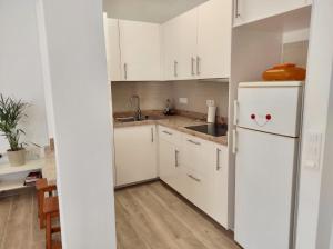 a kitchen with white cabinets and a white refrigerator at APARTAMENTO en PLAYA CALERA in Valle Gran Rey