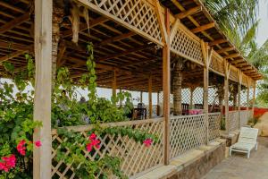 a wooden pergola with a bench and pink flowers at Hotel El Casino in Casares