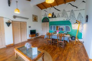 a living room with a table and a food truck at Seclude Ramgarh Arthouse in Nainital