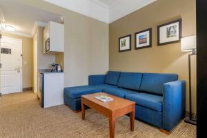 Comfort Suites Savannah North في بورت وينتورث: غرفة معيشة مع أريكة زرقاء وطاولة