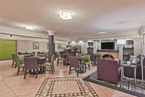 a restaurant with tables and chairs and a fireplace at Travelodge by Wyndham Houston Cy-Fair in Houston