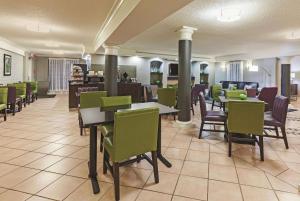 a restaurant with tables and chairs in a cafeteria at Travelodge by Wyndham Houston Cy-Fair in Houston