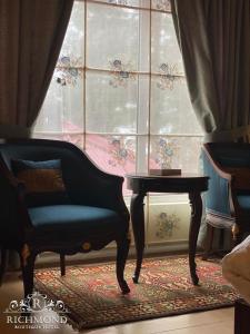 a room with a chair and a table and a window at Richmond Boutique Hotel in Nathia Gali