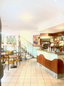 a restaurant with tables and chairs and a counter at Hotel San Siro Fiera in Milan