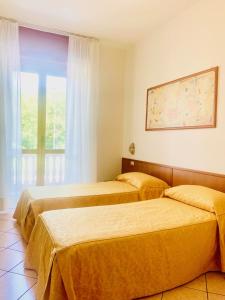 duas camas num quarto de hotel com uma janela em Hotel San Siro Fiera em Milão