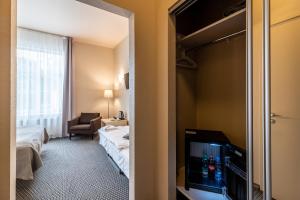 a room with a bed, a refrigerator, and a window at Hotel Sigulda in Sigulda