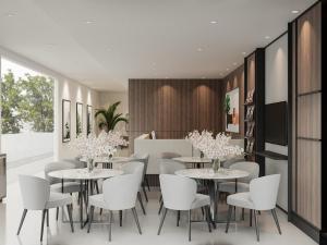 a dining room with white tables and white chairs at Tree On Hotel Syariah in Peterongan