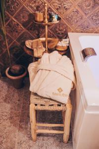 una toalla sentada en una silla junto a un lavabo en Amira 1899 Luxury Suite, en Galatina