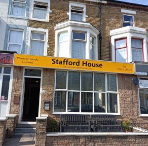 une maison de starford avec un panneau jaune sur un bâtiment dans l'établissement Stafford House, à Blackpool