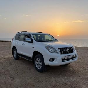 a white suv parked on the beach near the ocean at Studio Relax in Dakhla