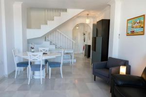 jadalnia i salon ze stołem i krzesłami w obiekcie Casa Ekman Fuentesol Casasol w mieście Nerja