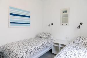 dwa łóżka w pokoju z białymi ścianami w obiekcie Casa Ekman Fuentesol Casasol w mieście Nerja