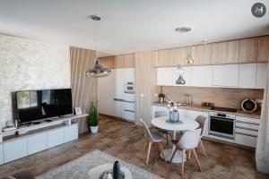 a kitchen with white cabinets and a table and chairs at AH Nová Terasa II in Košice
