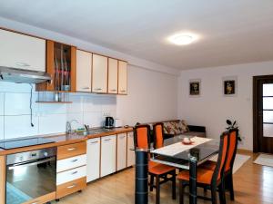 a kitchen with a table and a dining room at Lend apartment in Miercurea-Ciuc