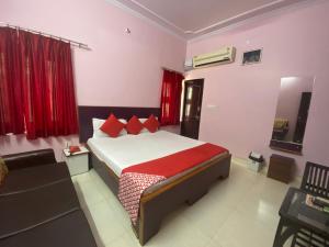 齋浦爾的住宿－Hotel Aarjee Crescent Jaipur，一间卧室配有红色枕头的床