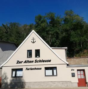 un edificio blanco con un cartel. en Ferienhaus Zur alten Schleuse en Wettin