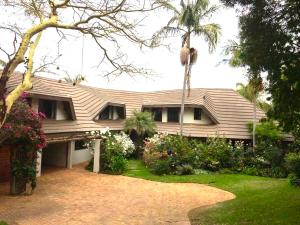una casa con una palma di fronte di Du Barry Guest House a Pretoria