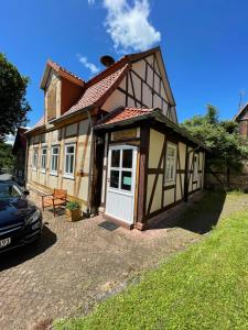 ein Haus mit einem davor geparkt in der Unterkunft Ferienwohnung Alte Dorfschule in Witzenhausen