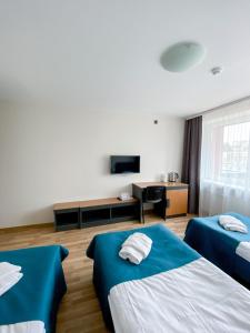 ein Hotelzimmer mit zwei Betten und einem Fernseher in der Unterkunft "AVA" apgyvendinimo įstaiga in Vilnius