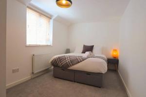 a white bedroom with a bed and a window at Hotwells Modern Mews in Bristol