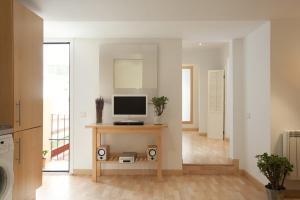 een woonkamer met een televisie op een tafel bij Homenfun Barcelona Montjuic in Barcelona