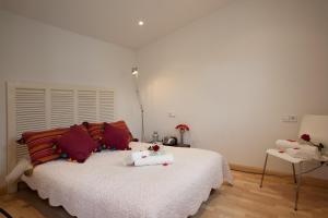 ein Schlafzimmer mit einem großen weißen Bett mit roten Kissen in der Unterkunft Homenfun Barcelona Montjuic in Barcelona