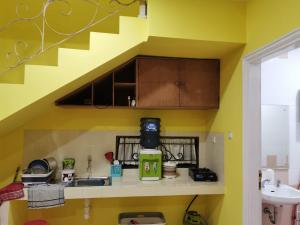 a small kitchen with a sink and a staircase at Villa Wubao Kota Bunga 3 Kamar Harga Budget in Cinengangirang +9 photos
