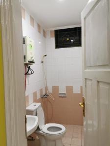 a bathroom with a toilet and a sink at Villa Wubao Kota Bunga 3 Kamar Harga Budget in Cinengangirang