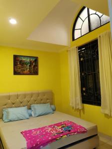 a bedroom with a bed with a pink blanket on it at Villa Wubao Kota Bunga 3 Kamar Harga Budget in Cinengangirang