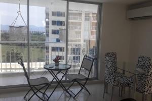 a table and chairs in a room with a window at Lindo apartamento cerca a Girardot in Ricaurte