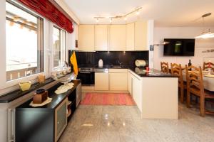 a kitchen with white cabinets and black counter tops at Apartment Castello in Grächen