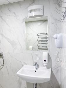 ein weißes Badezimmer mit Waschbecken und Spiegel in der Unterkunft "AVA" apgyvendinimo įstaiga in Vilnius + 20 Fotos