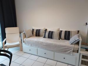 ein weißes Sofa mit Kissen darauf im Zimmer in der Unterkunft L'escale honfleuraise in Honfleur