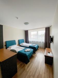um quarto de hotel com duas camas e uma mesa em "AVA" apgyvendinimo įstaiga em Vilnius
