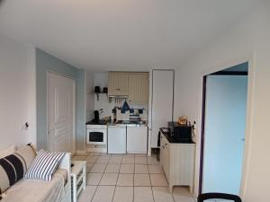 een woonkamer met een bank en een keuken bij L'escale honfleuraise in Honfleur