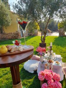 ein Picknicktisch mit Essen und Blumen auf dem Gras in der Unterkunft Cortijo Bustamante in Baza