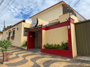 un edificio rojo y blanco con un reloj en él en Hotel Village Campinas, en Campinas