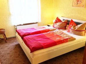 a bedroom with a bed with red sheets and pillows at Apartement Rosenbusch in Klausdorf Mecklenburg Vorpommern