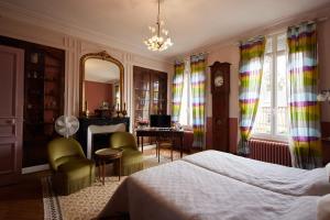 a bedroom with a bed and a desk and a clock at L'Antre de Gadag in Forges-les-Eaux